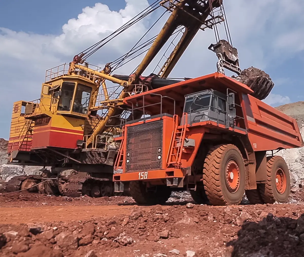 An excavator loading a haul truck at an open-pit mine